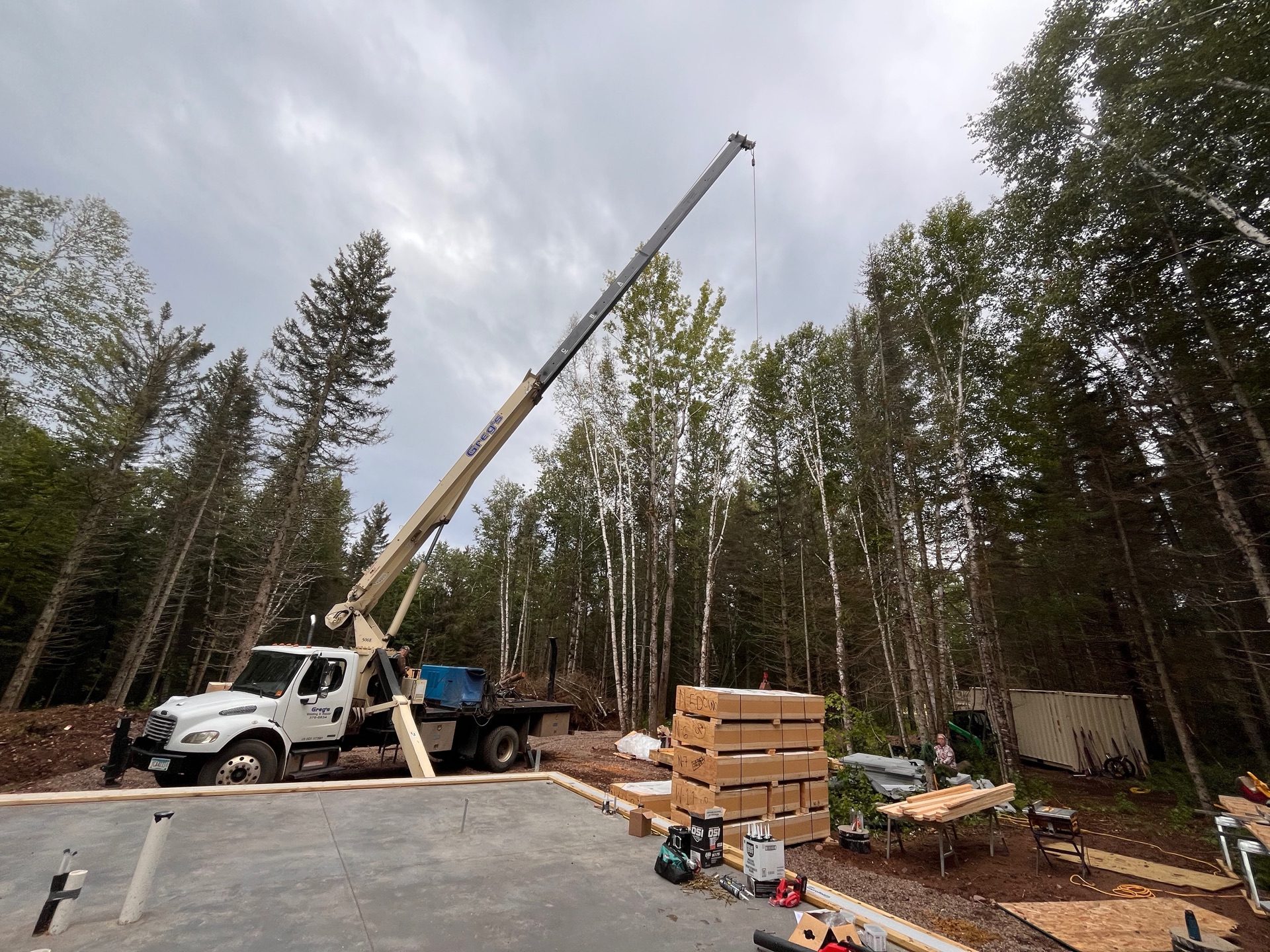 Construction crew lowering a pre-fabricated strawbale panel into place